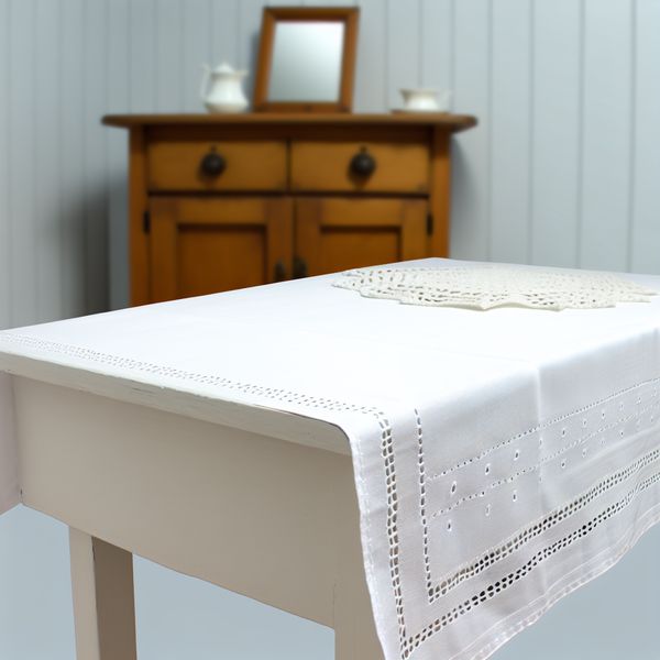Tafelkleed leren: minimalistisch interieur met decoratief doekje in Nederlandse stijl Minimalistisch tafelkleed op houten tafel met wit gestikt doekje en houten kast op de achtergrond in stijl van Dick Bruna